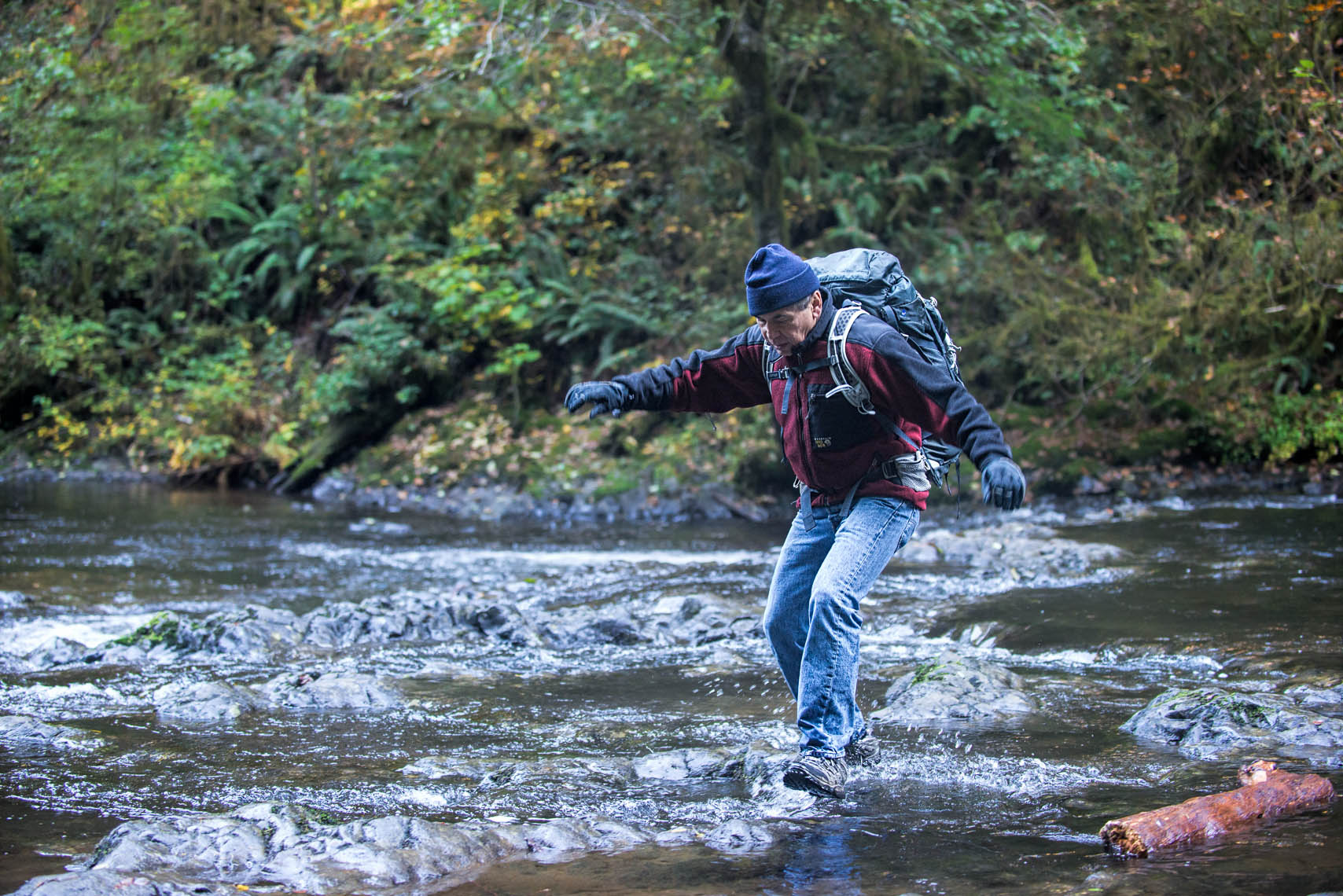 Backpacker crossing stream by Portland photographer, William Bragg